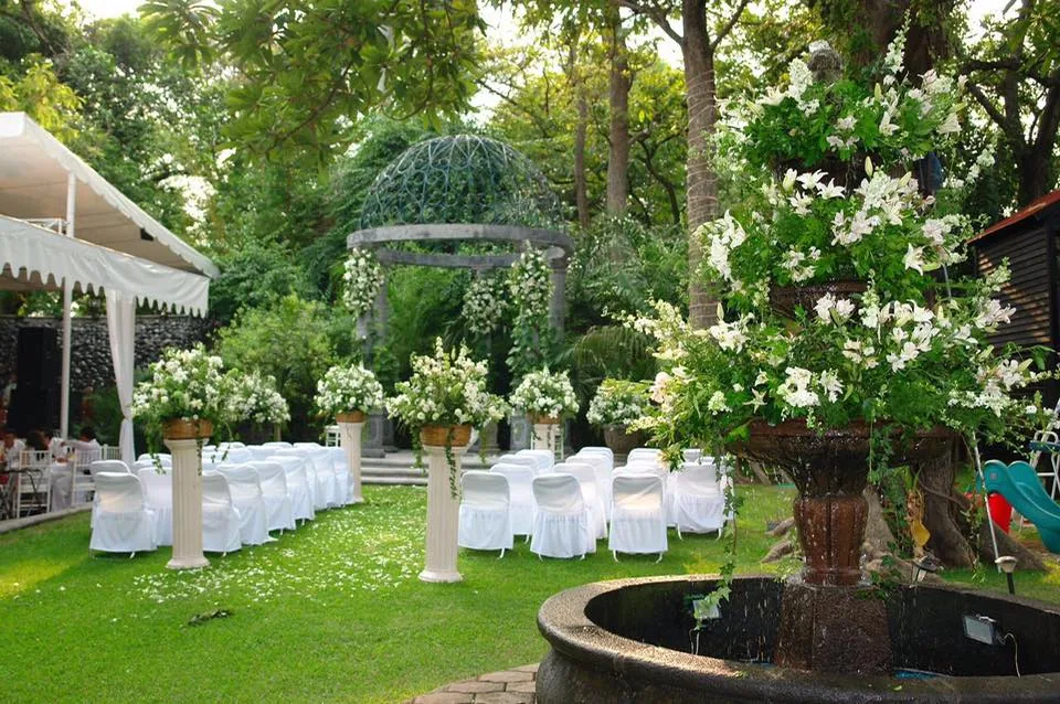 Ceremonia en jardín con fuente y flores